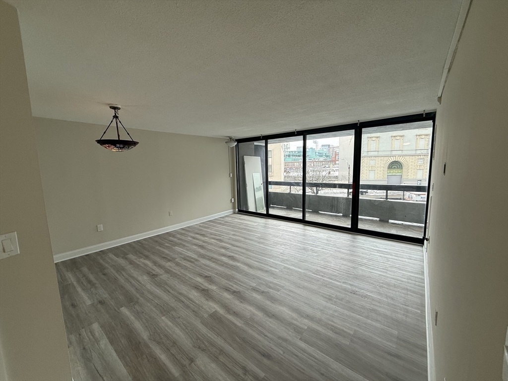 566 Commonwealth Avenue, Unit 308 Boston, MA 02215 - Photo 9 of 14 wooden floor in an empty room with a window