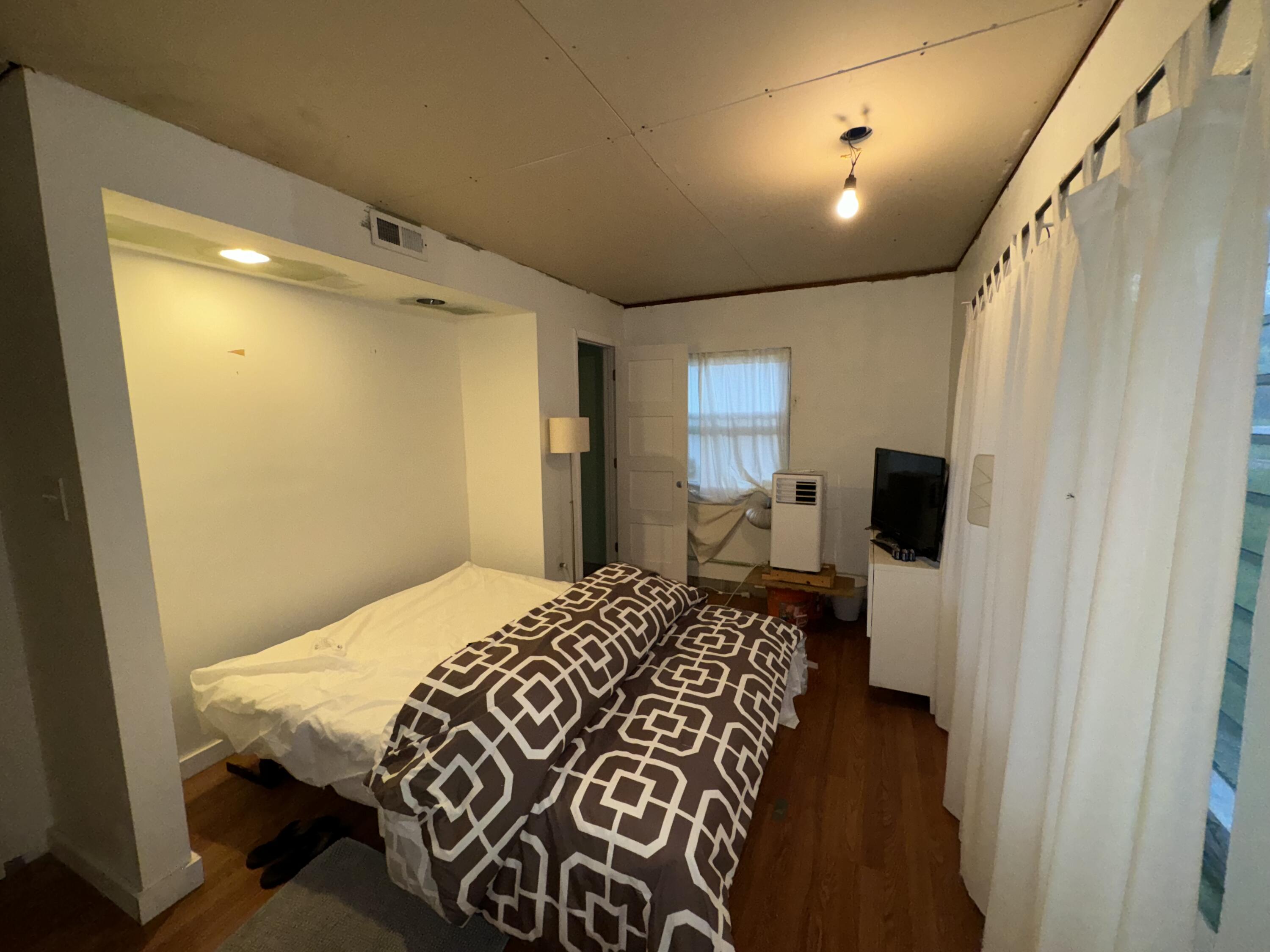 1825 Palm Boulevard Melbourne, FL 32901 - Photo 9 of 25 a bedroom with a bed and a mirror