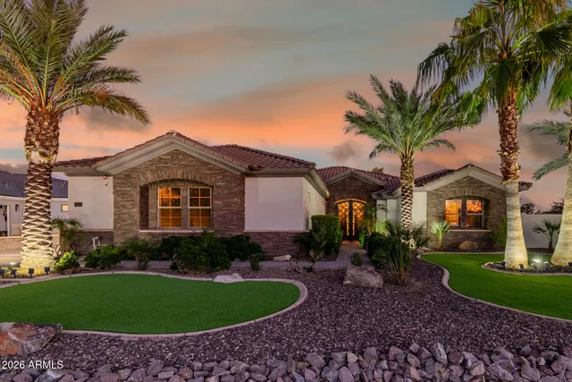 a front view of a house with a garden and trees