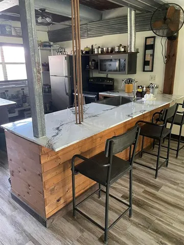a kitchen with stainless steel appliances granite countertop a sink and a refrigerator