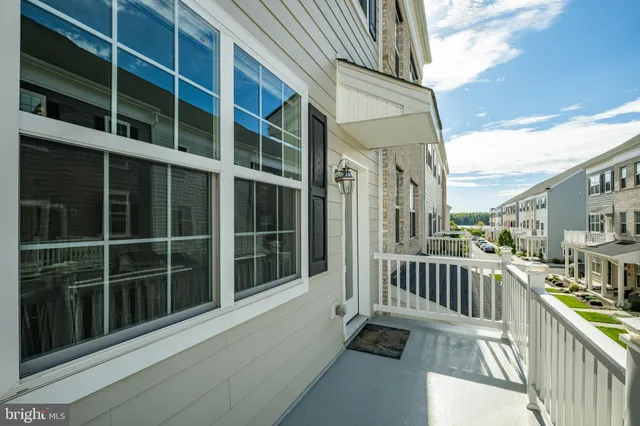 a view of a balcony with a large window and wooden fence