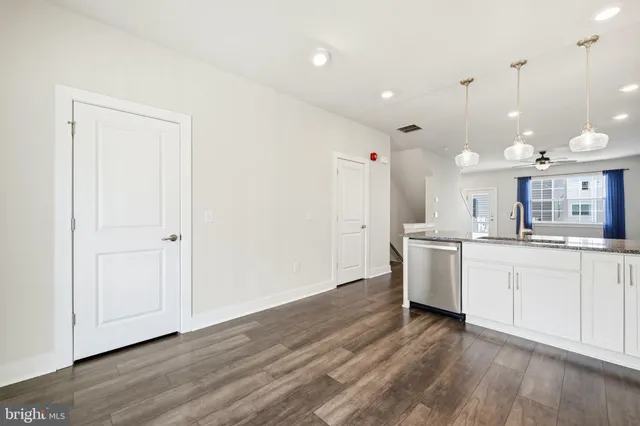 a large kitchen with a lot of counter space and a wooden floor