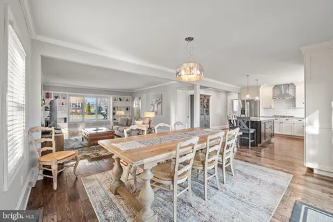 a view of a dining room and livingroom with furniture wooden floor and a rug