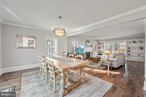 a view of a dining room with furniture a rug and wooden floor