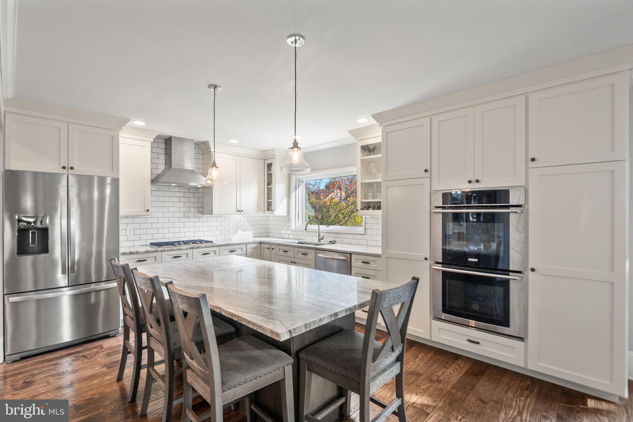 706 Fairview Avenue Frederick, MD 21701 - Photo 14 of 48 a kitchen with kitchen island a dining table chairs stainless steel appliances and cabinets