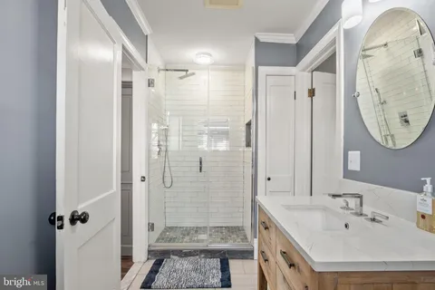 a bathroom with a double vanity sink mirror and shower