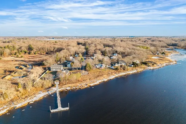 an aerial view of ocean and residential houses with outdoor space