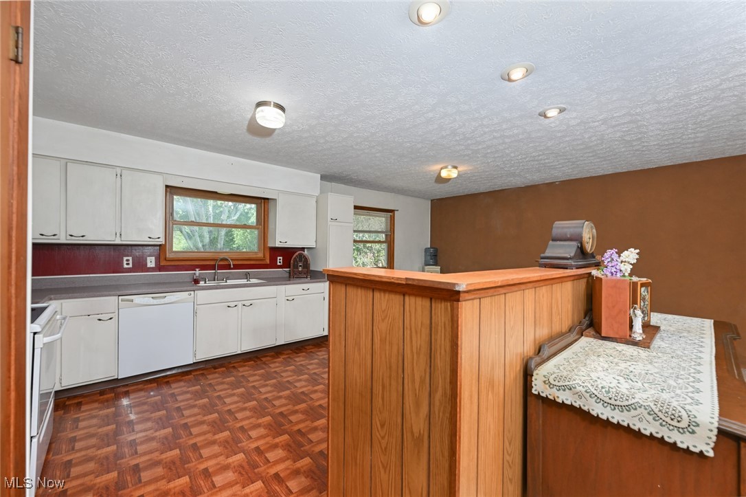 3079 Stroup Road Atwater, OH 44201 - Photo 15 of 40 Welcome to 3079 Stroup Rd, Atwater, OH 44201-9105 - this view of the kitchen shows the white appliances, sink, and white cabinets, and a bar/island.
