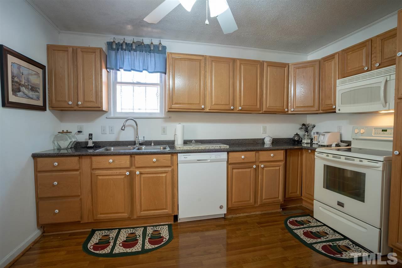 3411 Freeman Road Durham, NC 27703 - Photo 11 of 24 a kitchen with granite countertop a stove a sink and a refrigerator