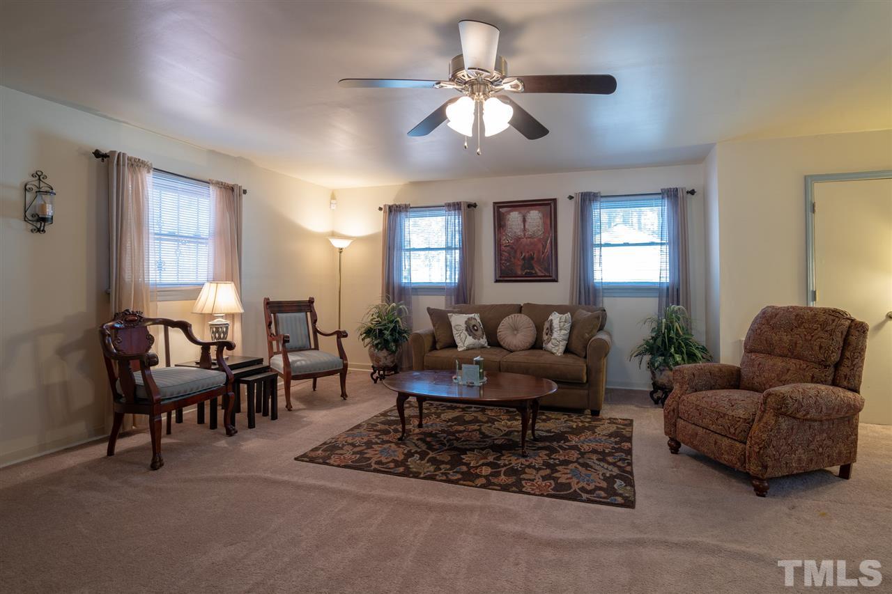 3411 Freeman Road Durham, NC 27703 - Photo 12 of 24 a living room with furniture and a chandelier