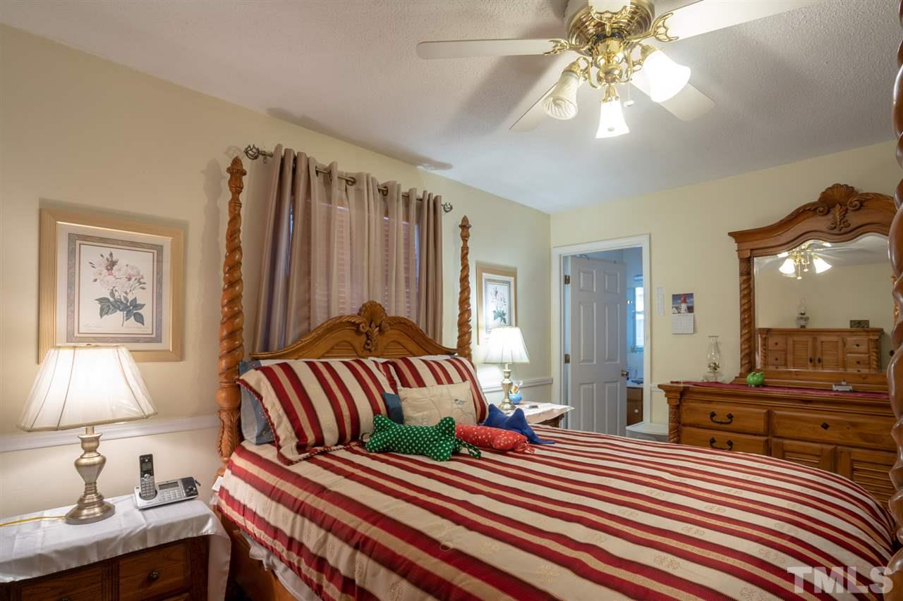 3411 Freeman Road Durham, NC 27703 - Photo 16 of 24 a bedroom with a bed and a chandelier