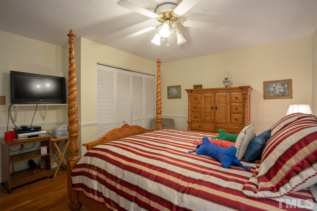 3411 Freeman Road Durham, NC 27703 - Photo 17 of 24 a bedroom with a bed and a flat tv screen on dresser