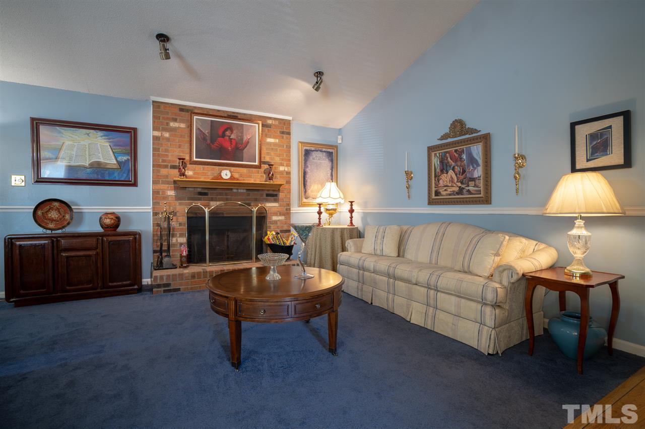 3411 Freeman Road Durham, NC 27703 - Photo 5 of 24 a living room with furniture a flat screen tv and a fireplace