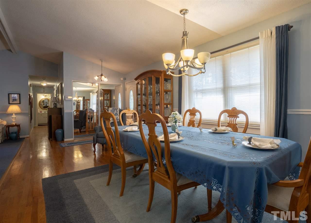 3411 Freeman Road Durham, NC 27703 - Photo 8 of 24 a view of a dining room with furniture wooden floor and chandelier
