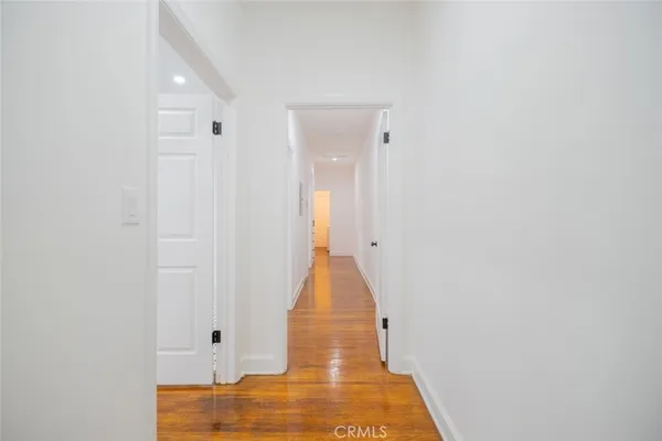 a view of a hallway with wooden floor