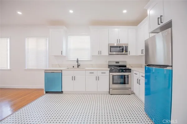 a kitchen with stainless steel appliances granite countertop a stove a sink and a refrigerator