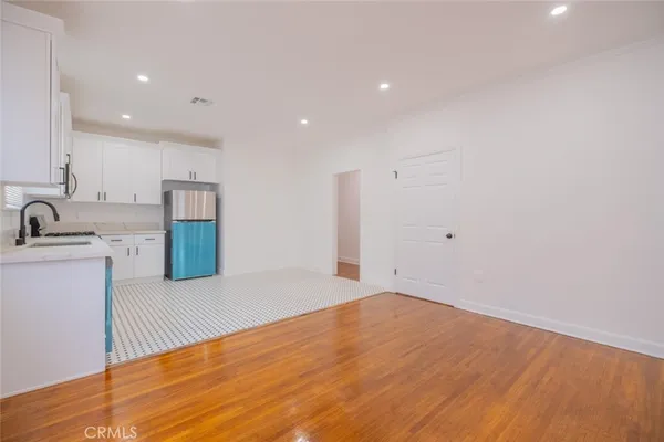 a view of a kitchen with refrigerator and white cabinets