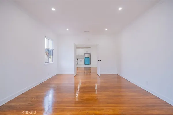 a view of empty room with wooden floor