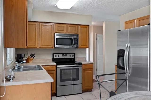a kitchen with kitchen island granite countertop a stove top oven microwave and refrigerator