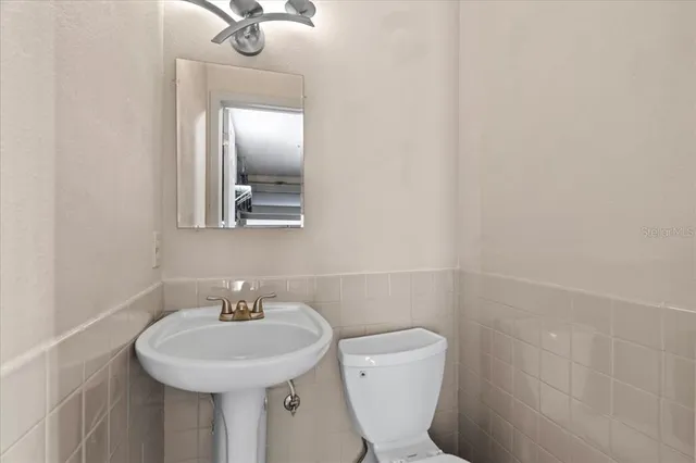 a bathroom with a toilet sink and mirror