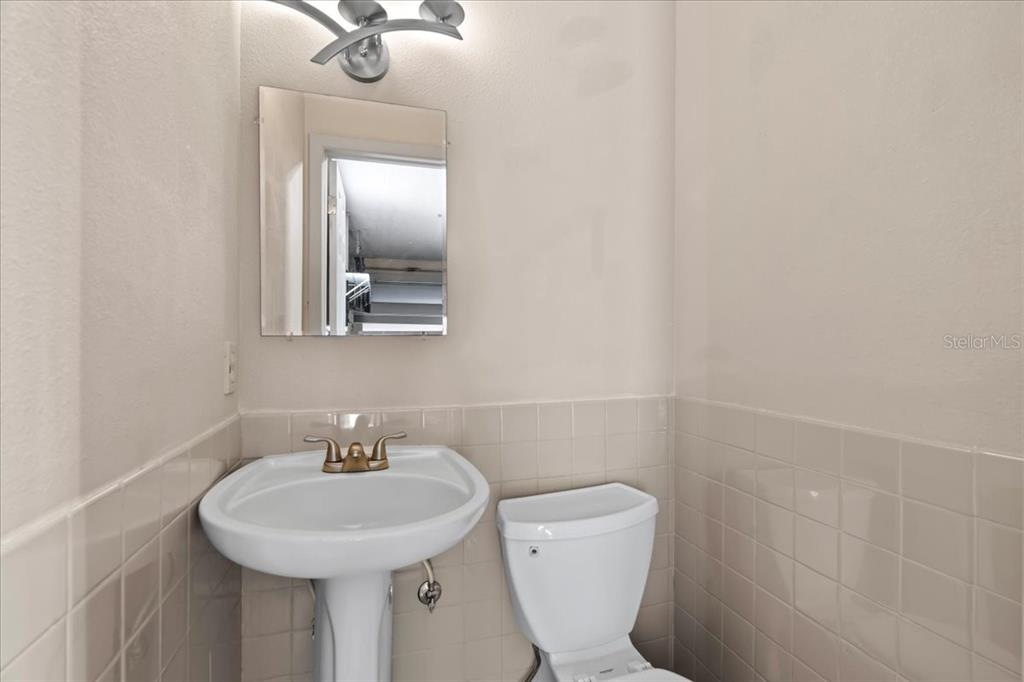 7041 Daggett Terrace New Port Richey, FL 34655 - Photo 28 of 29 a bathroom with a toilet sink and mirror