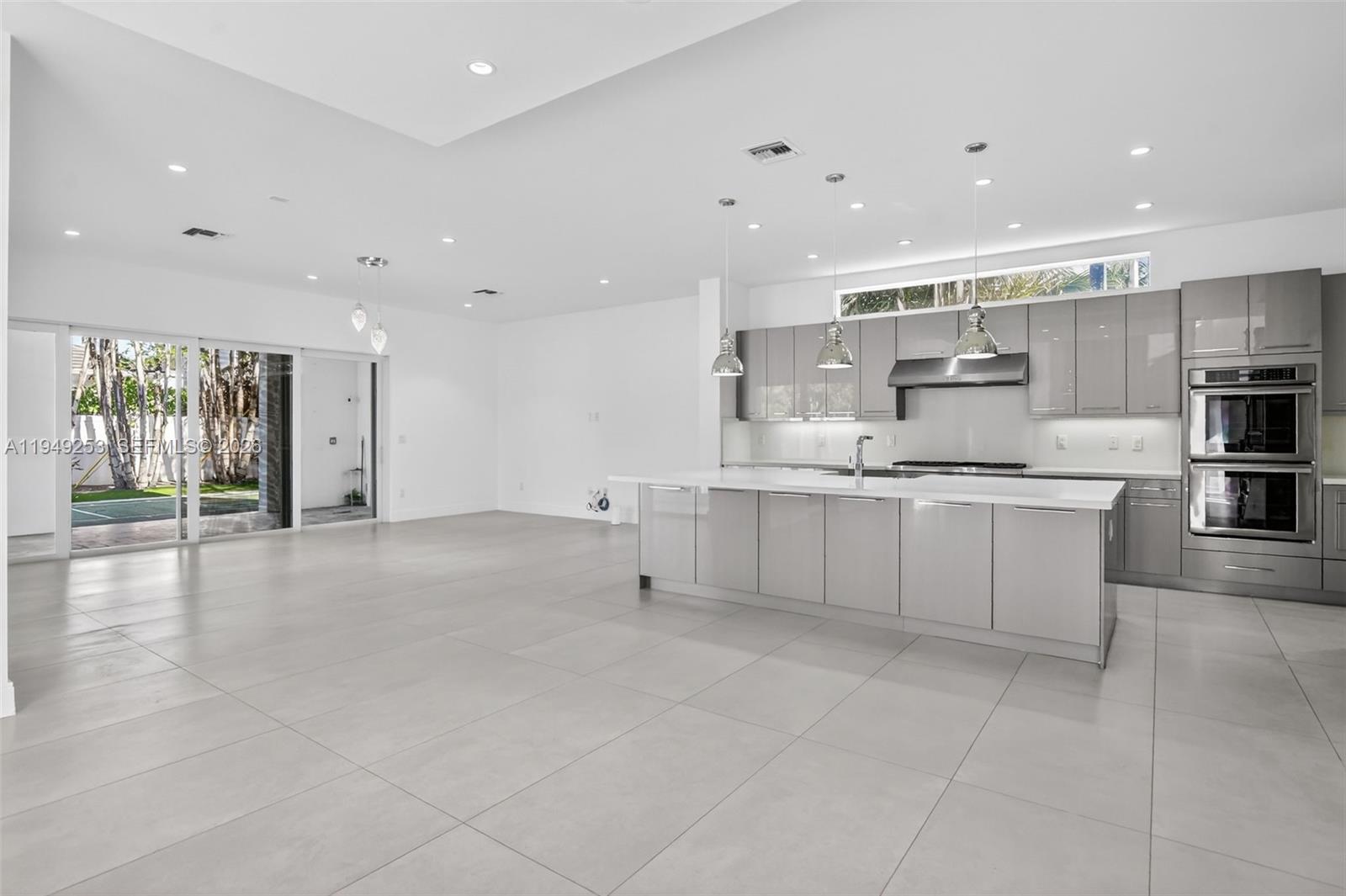 201 Northeast 6th Street Boca Raton, FL 33432 - Photo 17 of 100 a large white kitchen with kitchen island a sink a center island stainless steel appliances and a cabinets