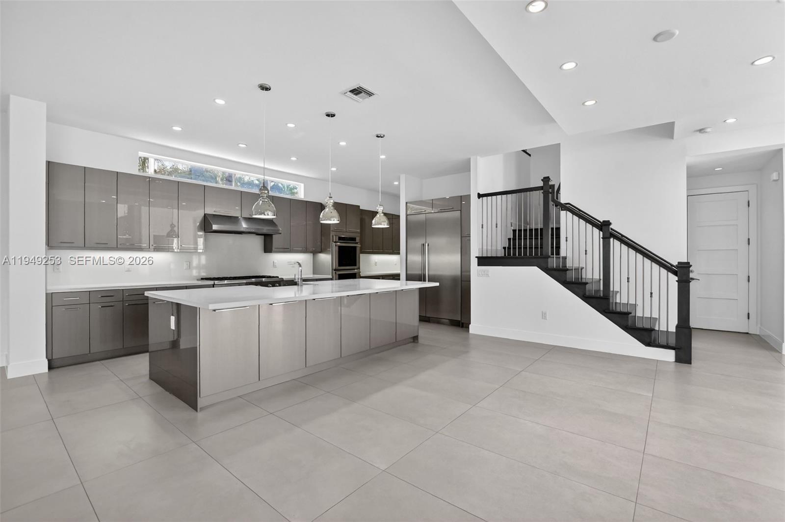 201 Northeast 6th Street Boca Raton, FL 33432 - Photo 4 of 100 a large white kitchen with a large counter top stainless steel appliances and cabinets