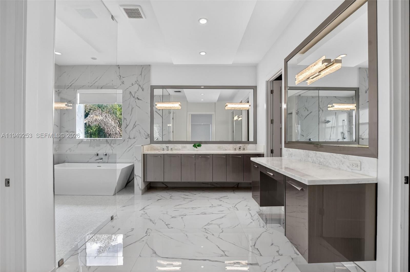 201 Northeast 6th Street Boca Raton, FL 33432 - Photo 49 of 100 a bathroom with a tub a double vanity sink a mirror and a bathtub