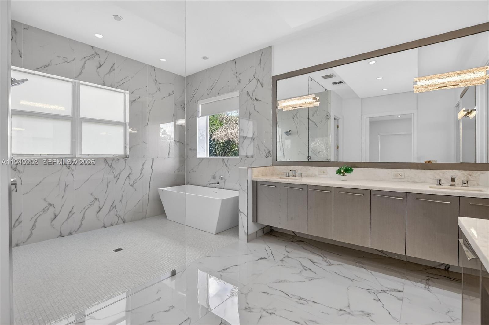 201 Northeast 6th Street Boca Raton, FL 33432 - Photo 50 of 100 a bathroom with a double vanity sink mirror and bathtub