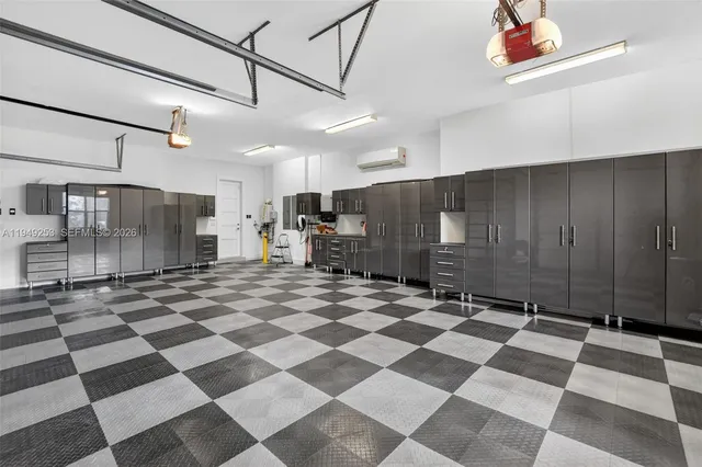 a large white kitchen with kitchen island a sink a center island stainless steel appliances and a cabinets