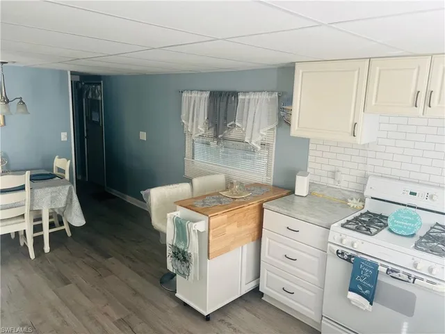 a kitchen with a stove and wooden floor