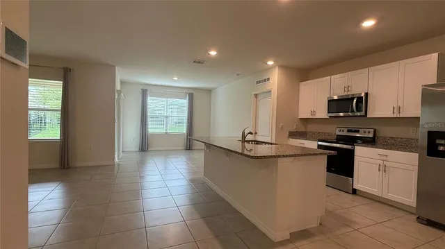 a kitchen with stainless steel appliances a sink a stove a microwave and cabinets