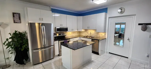 a kitchen with stainless steel appliances granite countertop a refrigerator a stove a sink and a refrigerator