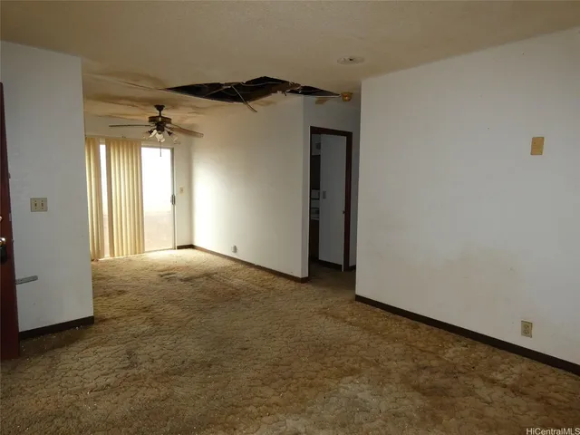 a view of a big room with a windows and a ceiling fan