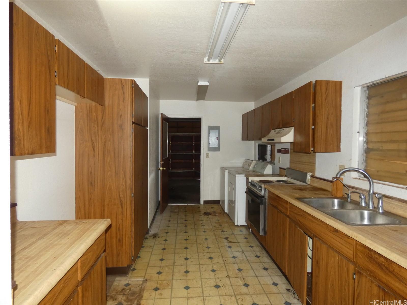94-605 Kupuna Loop Waipahu, HI 96797 - Photo 3 of 12 a kitchen with a sink stove and refrigerator