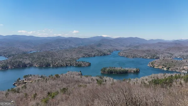 a view of lake with mountain and trees