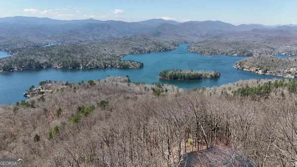 a view of a dry field with mountains in the background