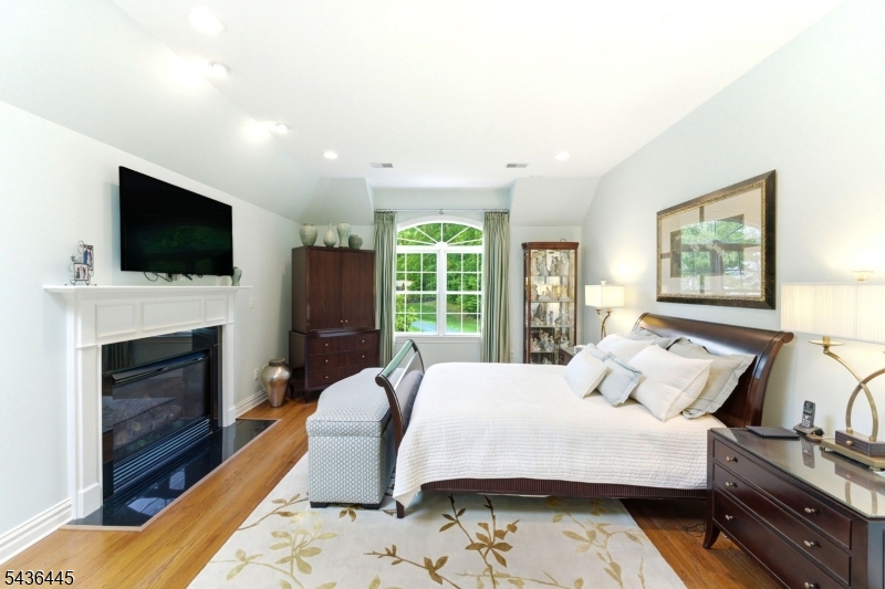 4 Windemere Way Sparta, NJ 07871 - Photo 23 of 50 a bedroom with a bed a flat screen tv and a fireplace