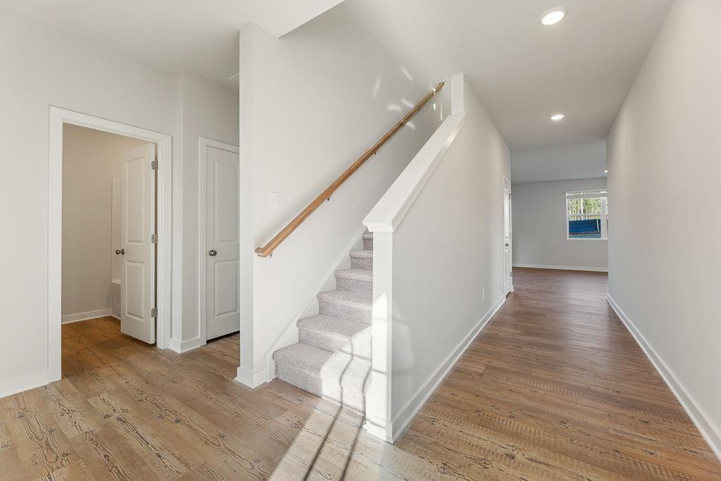 542 Arborston Way Jefferson, GA 30549 - Photo 5 of 28 a view of a hallway with wooden floor and staircase