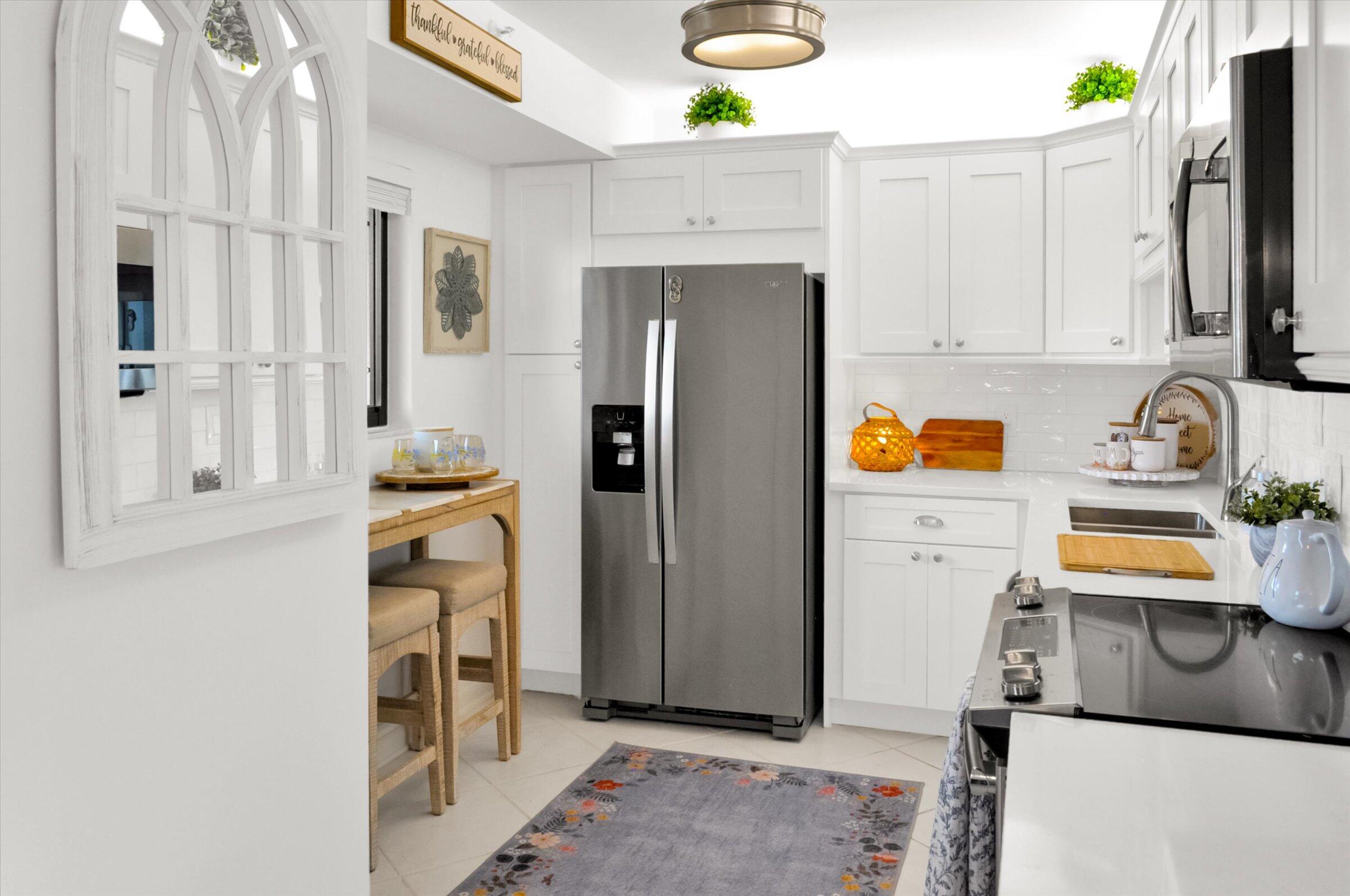 400 Ocean Trail Way, Unit 703 Jupiter, FL 33477 - Photo 18 of 63 a kitchen with stainless steel appliances granite countertop a refrigerator and a stove
