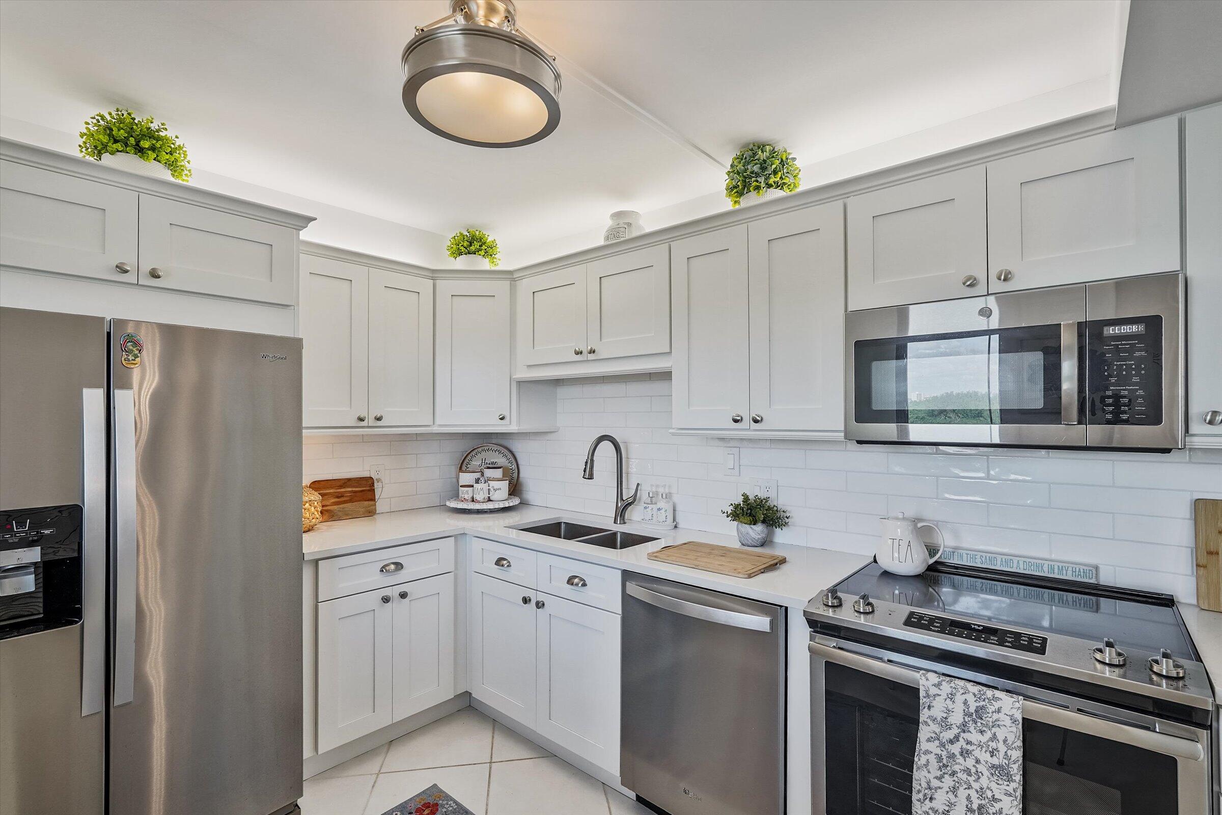 400 Ocean Trail Way, Unit 703 Jupiter, FL 33477 - Photo 21 of 63 a kitchen with cabinets stainless steel appliances and a sink