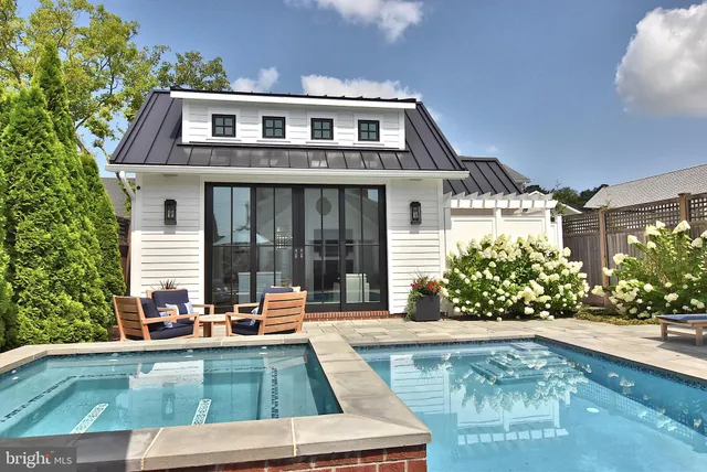 a view of a dining room and livingroom with furniture wooden floor a chandelier