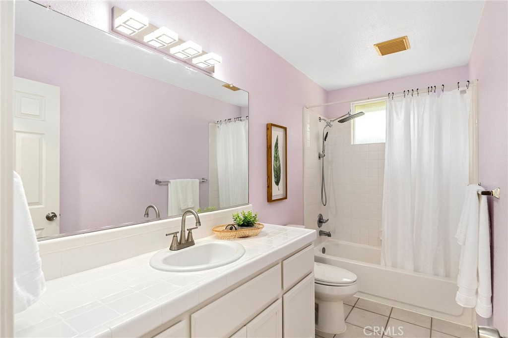 3011 Calistoga Drive Chico, CA 95973 - Photo 24 of 40 a bathroom with a granite countertop sink a toilet a mirror a vanity and shower