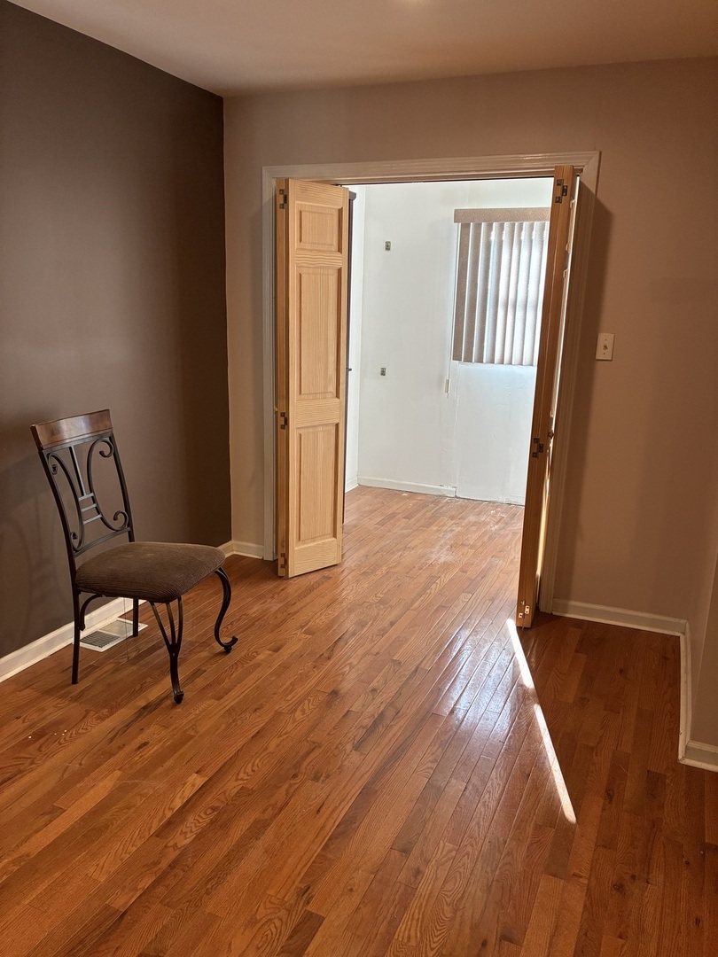 12346 South Indiana Avenue Chicago, IL 60628 - Photo 4 of 14 a view of a room with wooden floor and chair
