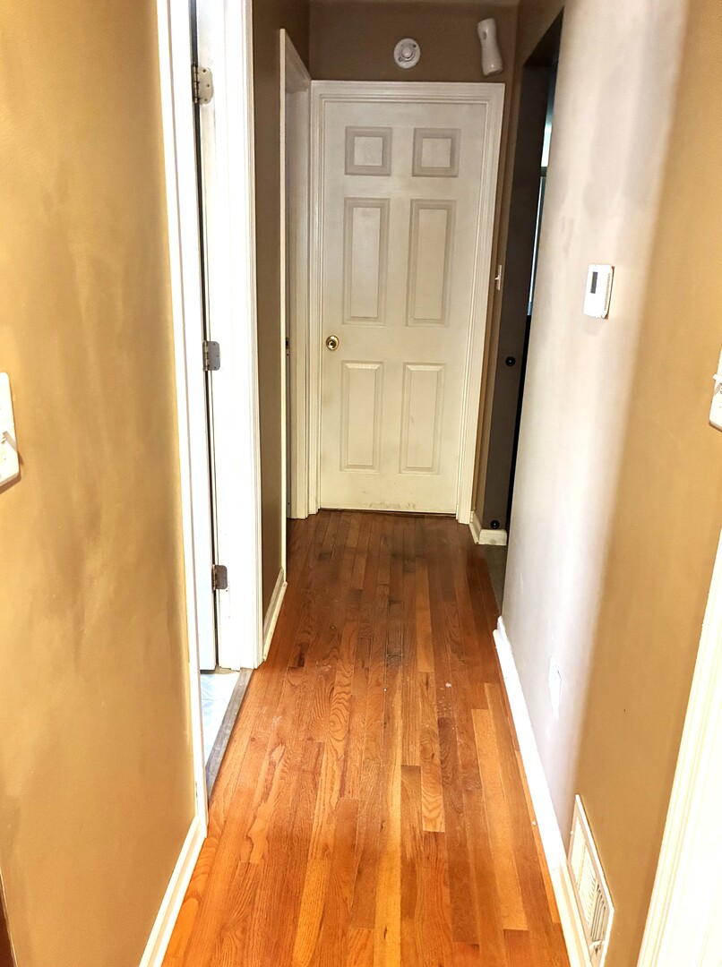 12346 South Indiana Avenue Chicago, IL 60628 - Photo 9 of 14 a view of a hallway with wooden floor