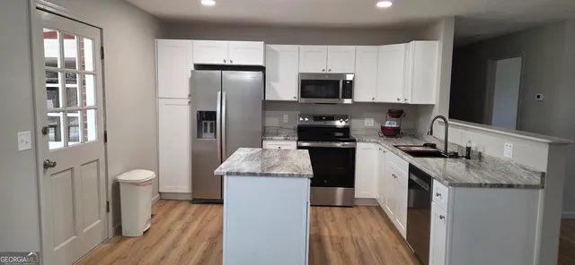 a kitchen with a refrigerator and a sink