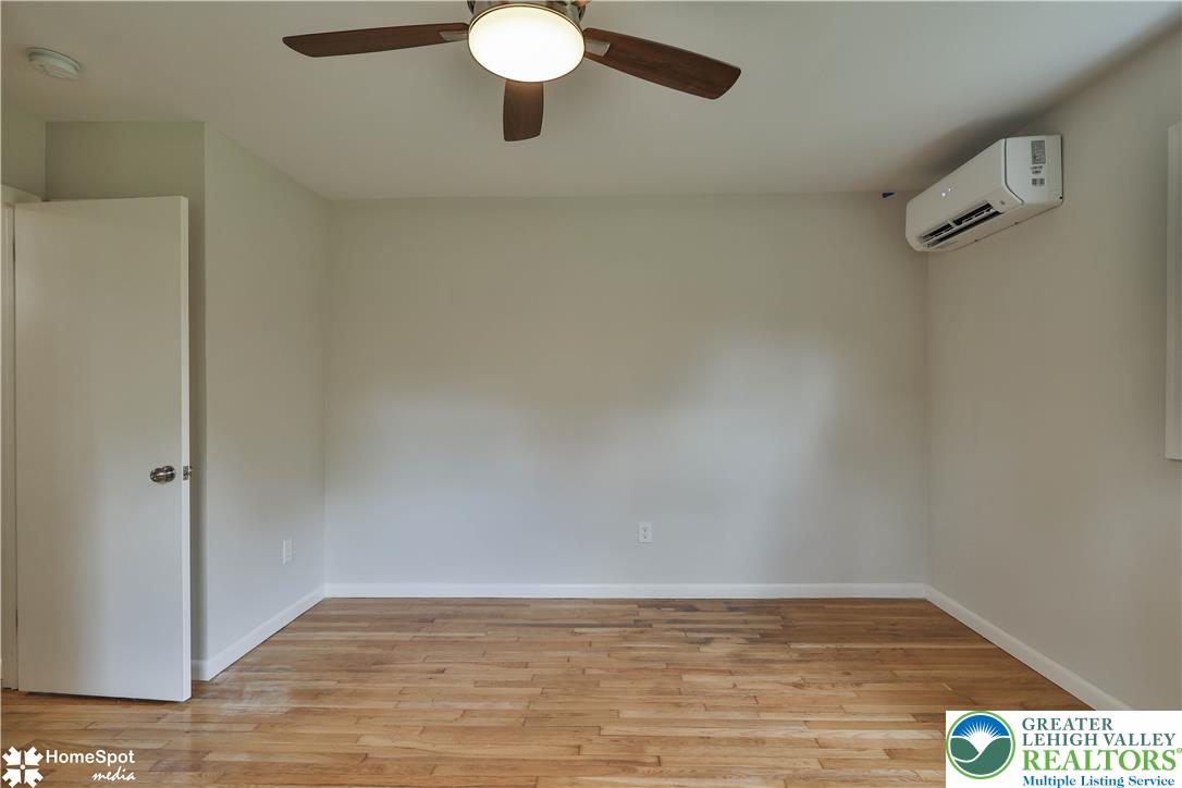 919 Point Phillips Road Bath, PA 18014 - Photo 40 of 59 Hardwood flooring extends throughout this versatile room, complemented by a ceiling fan and efficient wall-mounted cooling unit.