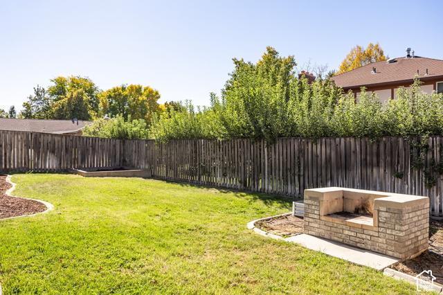1143 East Mountain Road Logan, UT 84321 - Photo 40 of 64 Expansive fenced yard featuring a grass lawn, wood privacy fencing, and a built-in outdoor brick cooking station