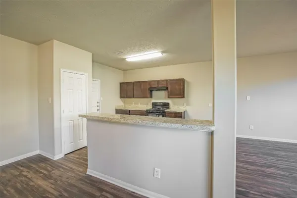 a view of a kitchen with wooden floor electronic appliances and windows