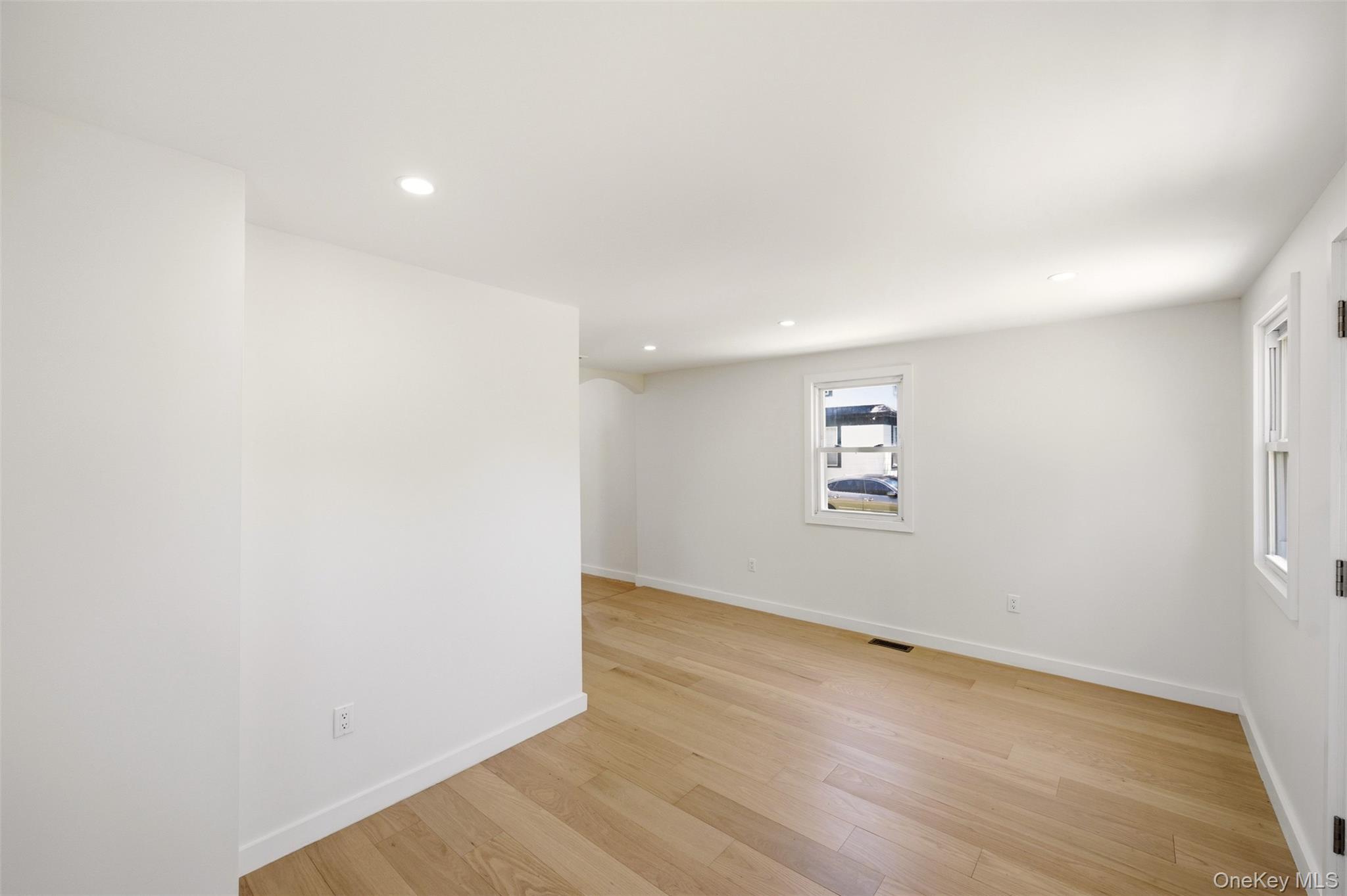 135 Whaley Street Freeport, NY 11520 - Photo 23 of 38 an empty room with wooden floor and windows